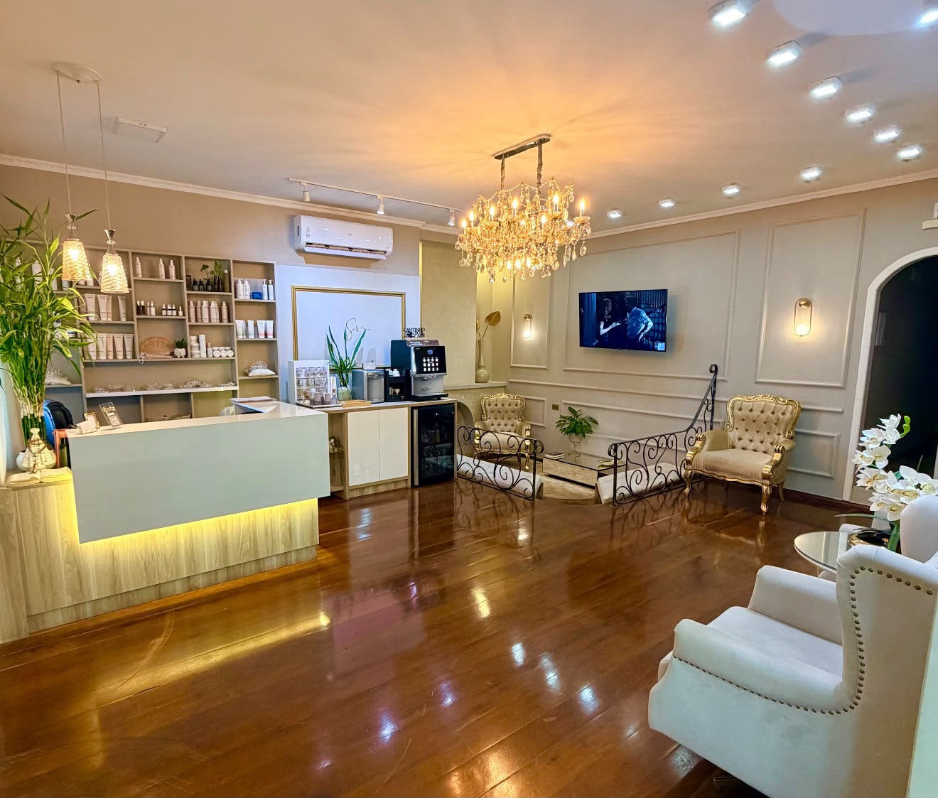Recepção do Studio com lustre de cristal, poltronas e espera aconchegante