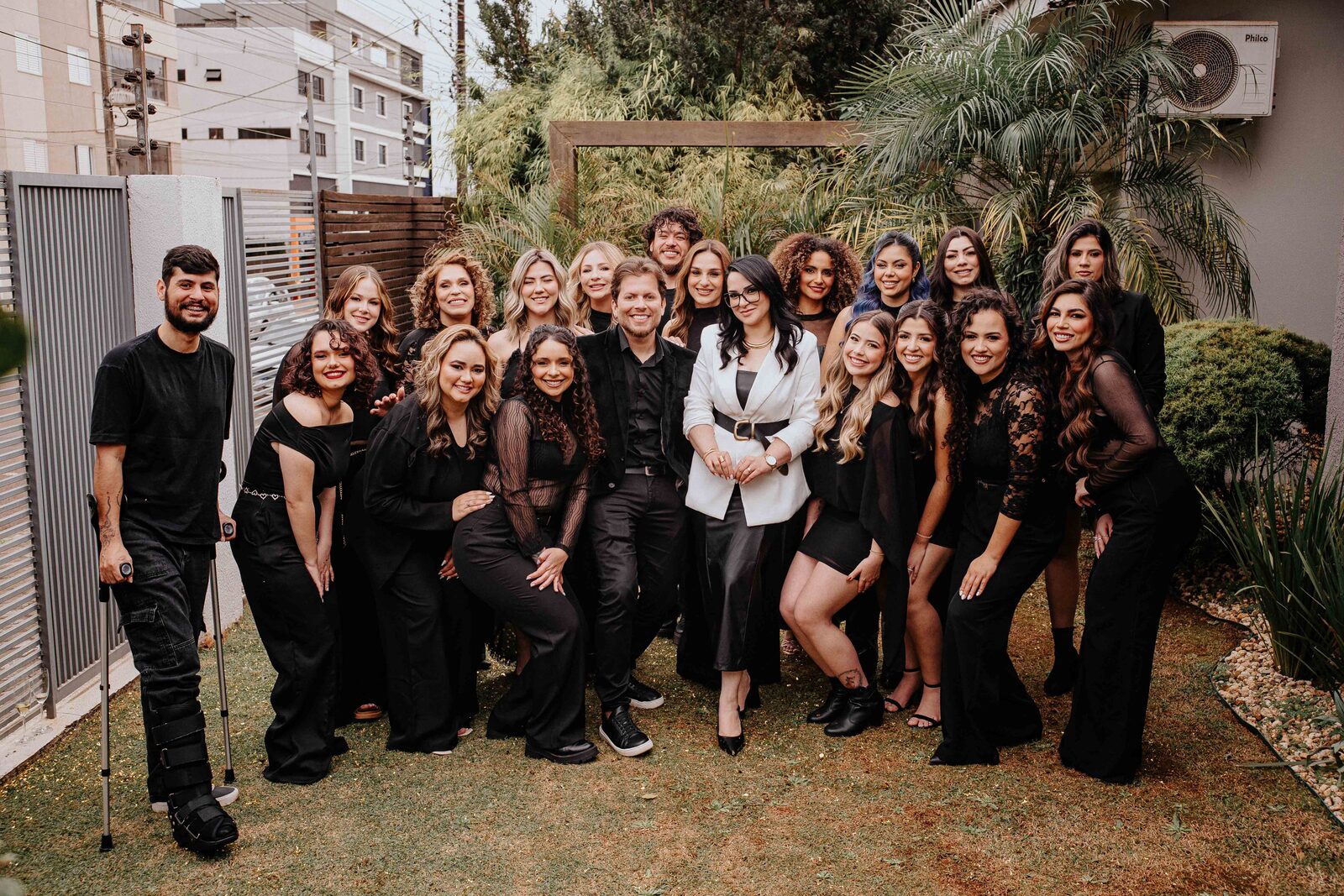 Equipe do Studio Gisele Raffaelli reunida na área externa do espaço, todos vestidos de preto